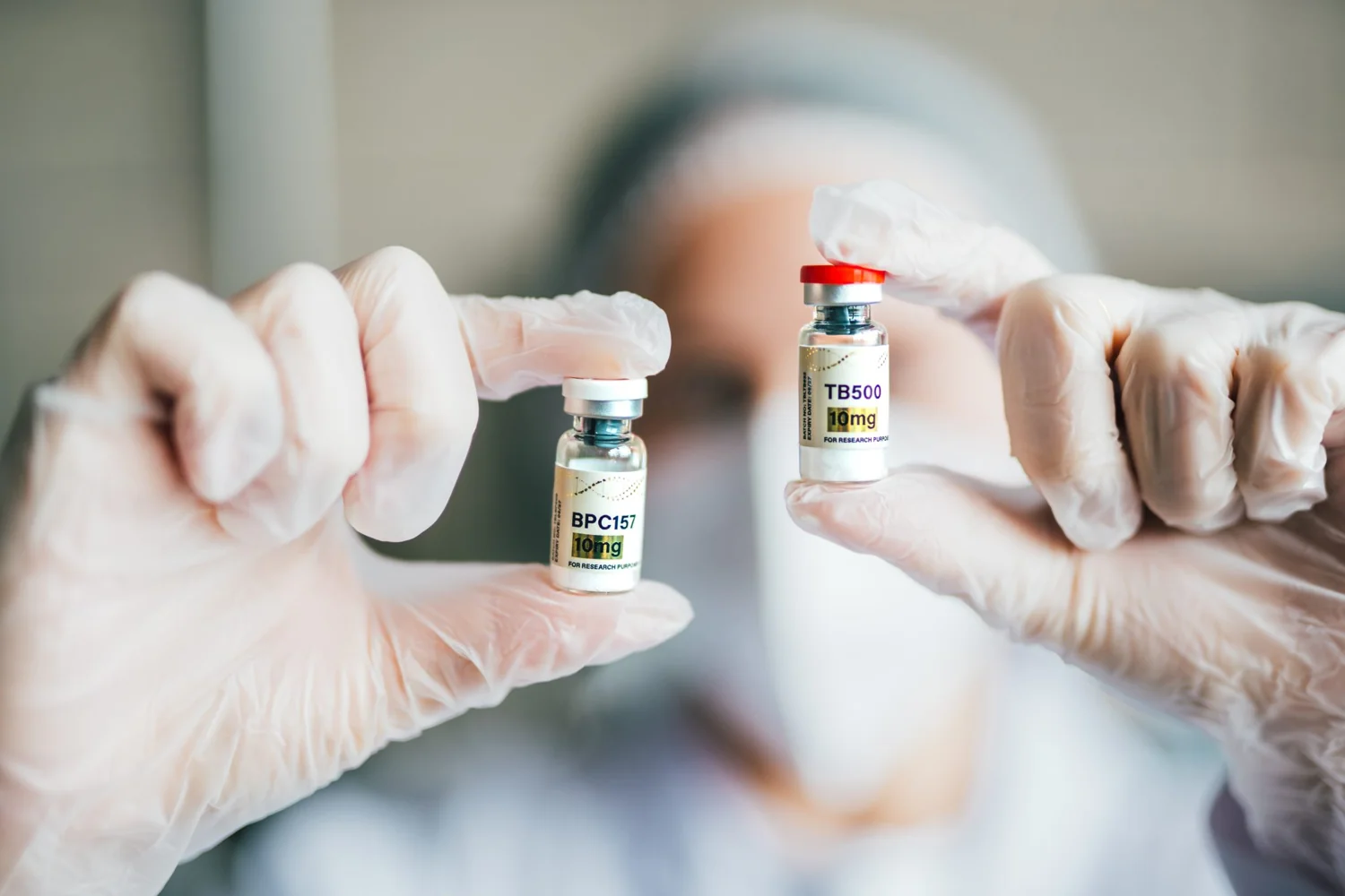 Gloved hands holding Thoroughbred Labs BPC157 and TB500 research vials